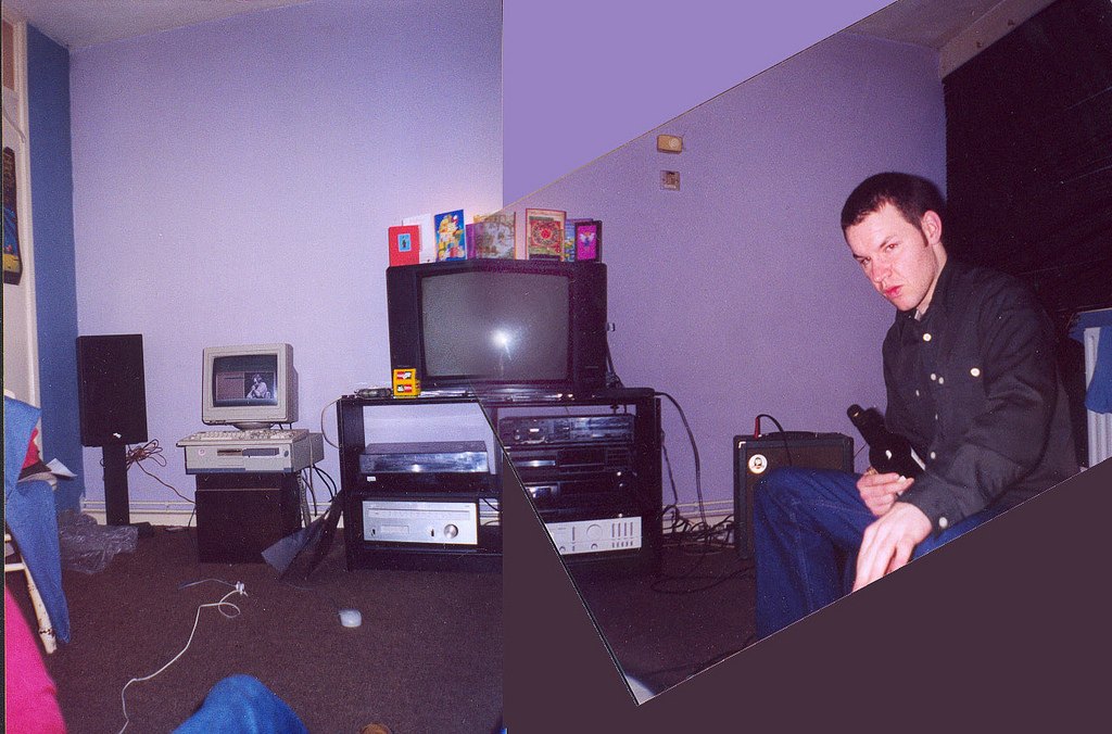 A cut-up of two photographs of the same front room: a hi-fi stack and an old computer against a lilac wall, and a man sitting beside a guitar amp holding a bottle.